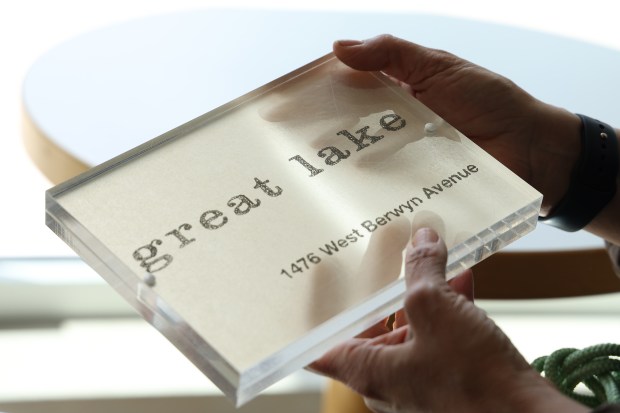 Owner Lydia Esparza places the only signage they have on the window ledge at Great Lake in Chicago's Anderson neighborhood on June 24, 2025. (Antonio Perez/Chicago Tribune)