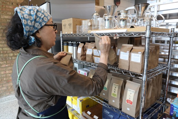 Owner Lydia Esparza places some of the grocery items on a shelf at Great Lake business in Chicago's Anderson neighborhood on June 24, 2025. (Antonio Perez/Chicago Tribune)