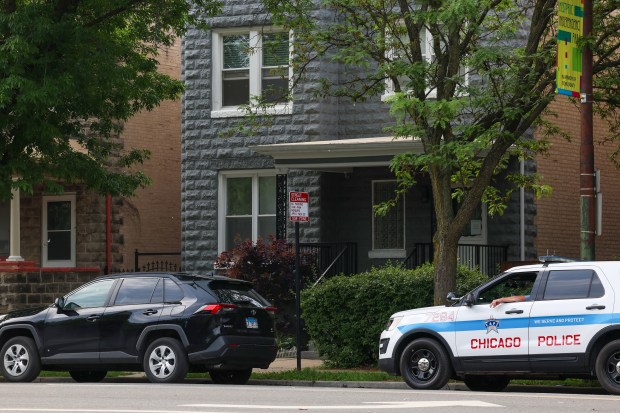 A Chicago police officer sits in an SUV outside the...