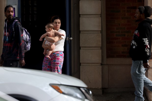 Neighbors watch as Chicago police put away evidence bags in...