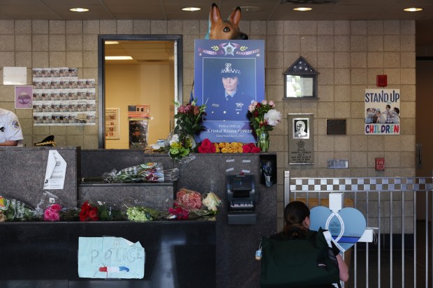 A mourner signs a cross dedicated to police Officer Krystal...