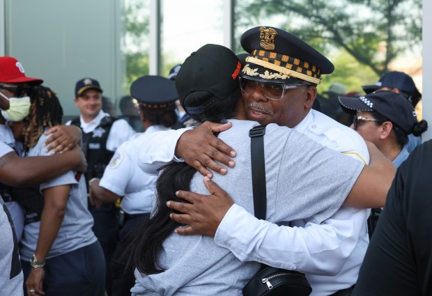 Cmdr. Michael Tate, 6th District, right, hugs an officer at...