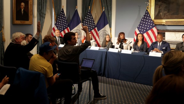 Reporters covering City Hall, including Chris Sommerfeldt at center, raise their hands to ask Mayor Eric Adams questions during an off-topic press conference at City Hall on Tuesday, Oct. 10, 2023. (Luiz C. Ribeiro for New York Daily News)