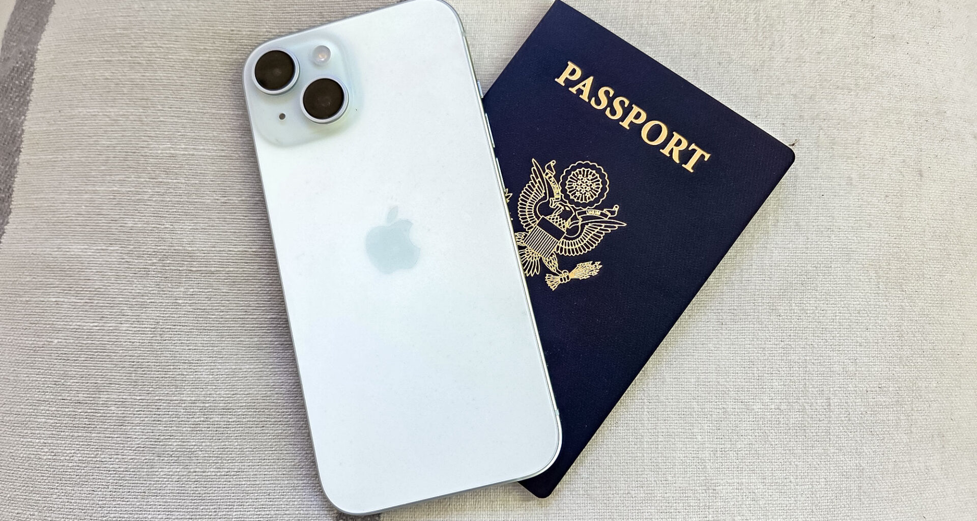 An iPhone 15 sitting on top of a U.S. passport