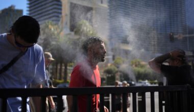 People cool off in misters during a heat wave along the Las Vegas Strip, Sunday, July 7, 2024, in Las Vegas. (AP Photo/John Locher)