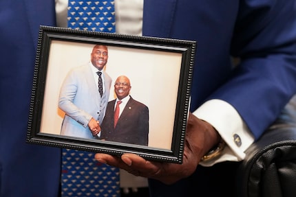 Mayor Pro Tem Tennell Atkins holds a photograph of himself with Magic Johnson as he goes...
