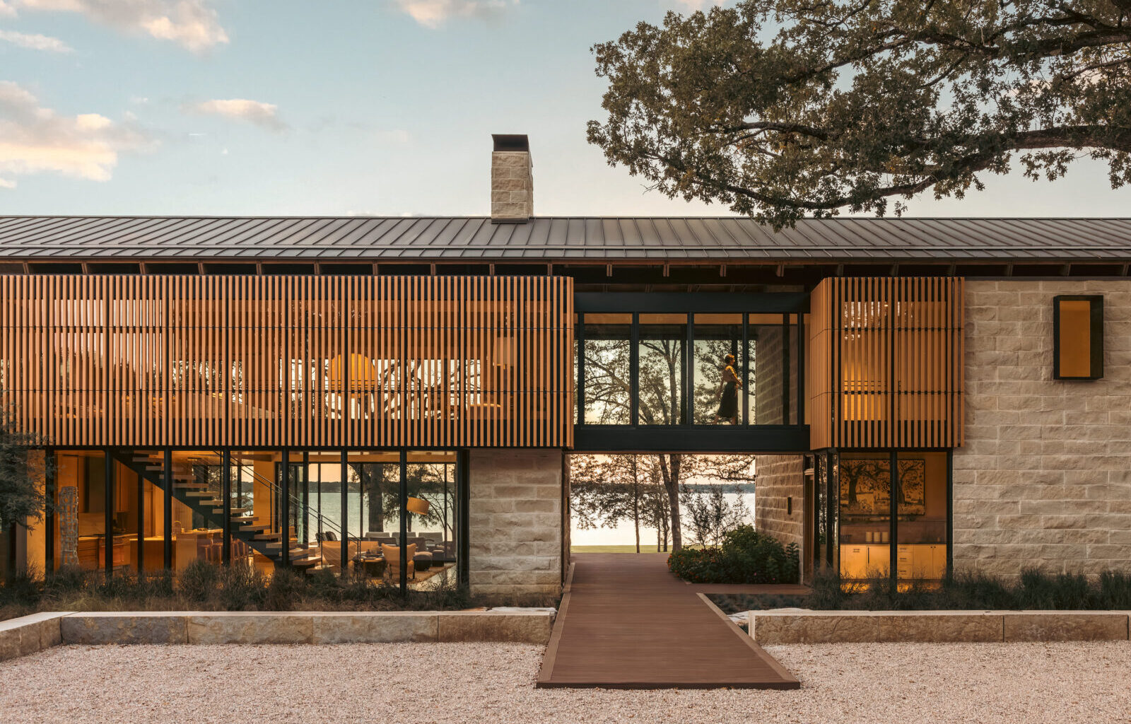 A lake house on the water with stone and wood textures