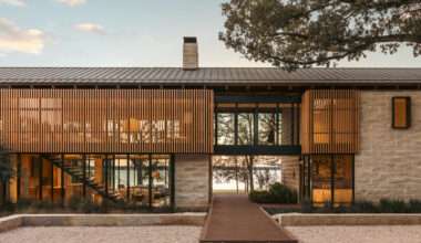A lake house on the water with stone and wood textures