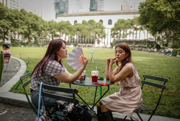 A woman holds a fan during a heat wave in New York City on June 22, 2025. (Photo by KENA BETANCUR/AFP via Getty Images)
