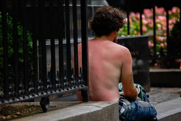 A man with a sunburn sits in a park during a heat wave in New York City on June 22, 2025. (Photo by KENA BETANCUR/AFP via Getty Images)
