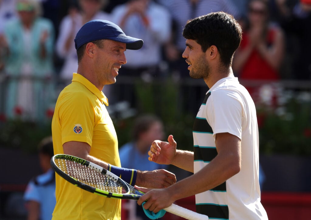 Carlos Alcaraz and Roberto Bautista Agut embrace at the net after their semi-final match at Queen's