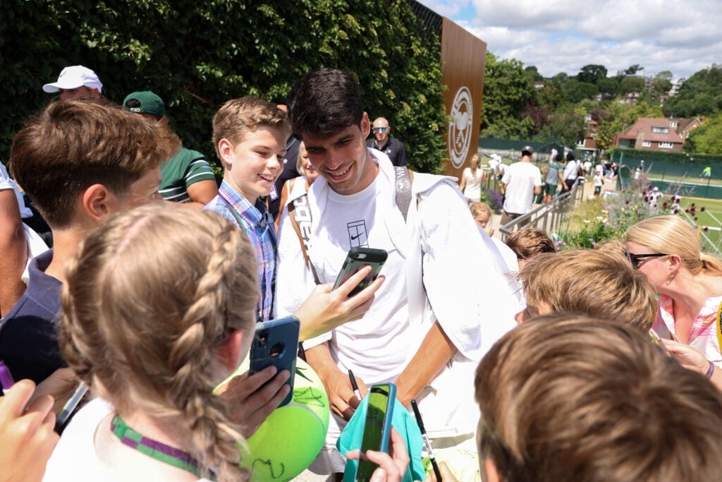 Carlos Alcaraz of Spain interacts with fans as he leaves the court after a practice session prior to The Championships Wimbledon 2025 at All England Lawn Tennis and Croquet Club.