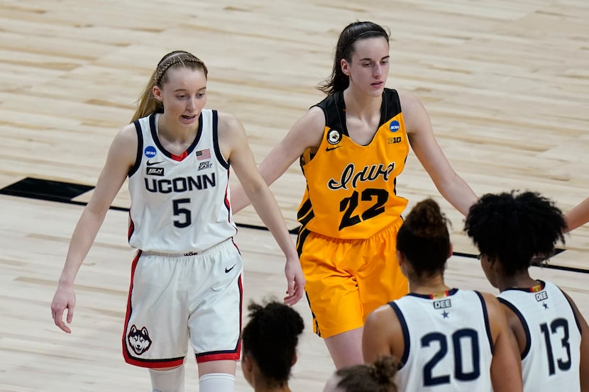 UConn guard Paige Bueckers (5) and Iowa guard Caitlin Clark (22) walk off the court after...