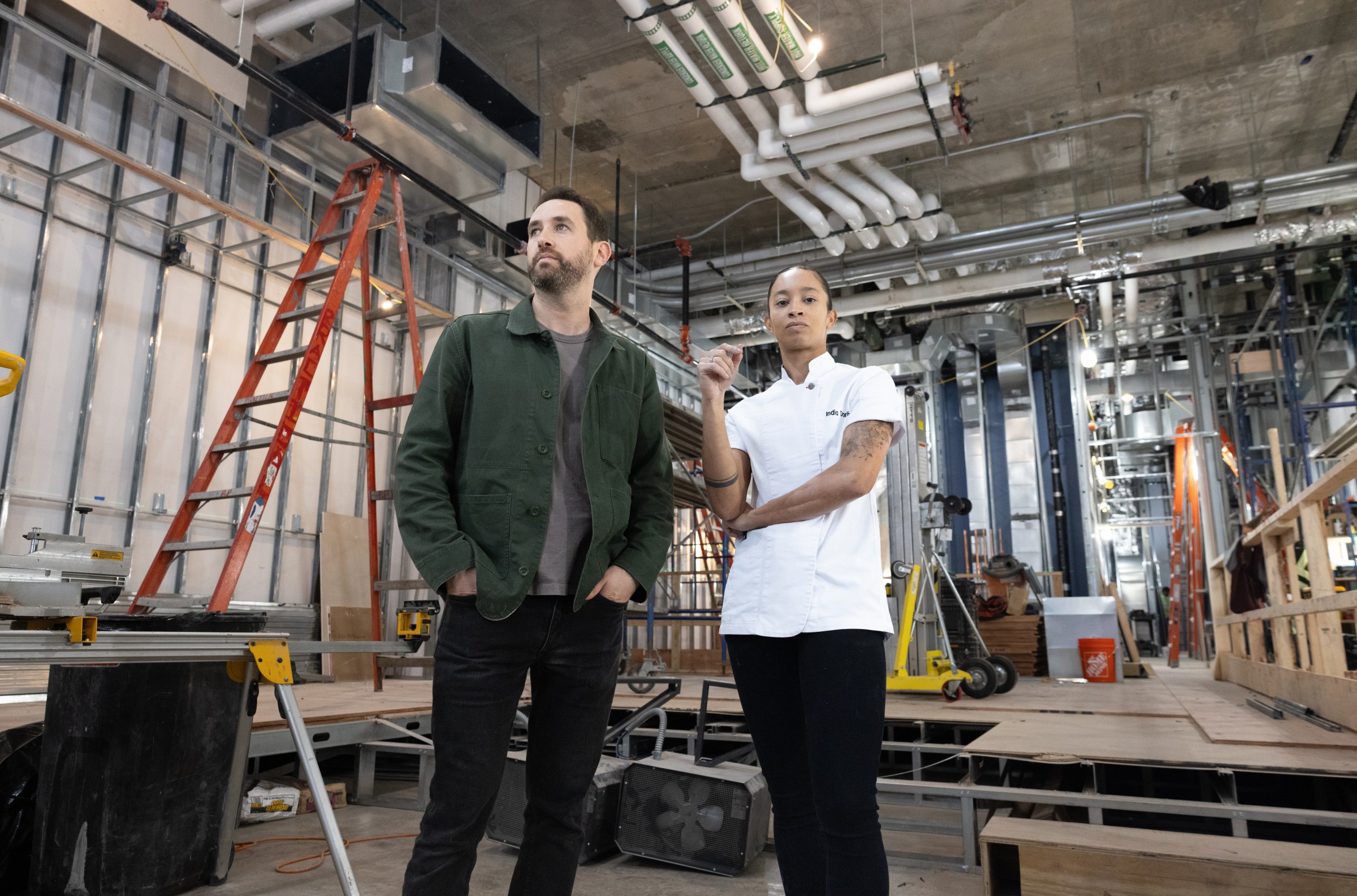 Two people standing in a room being constructed.