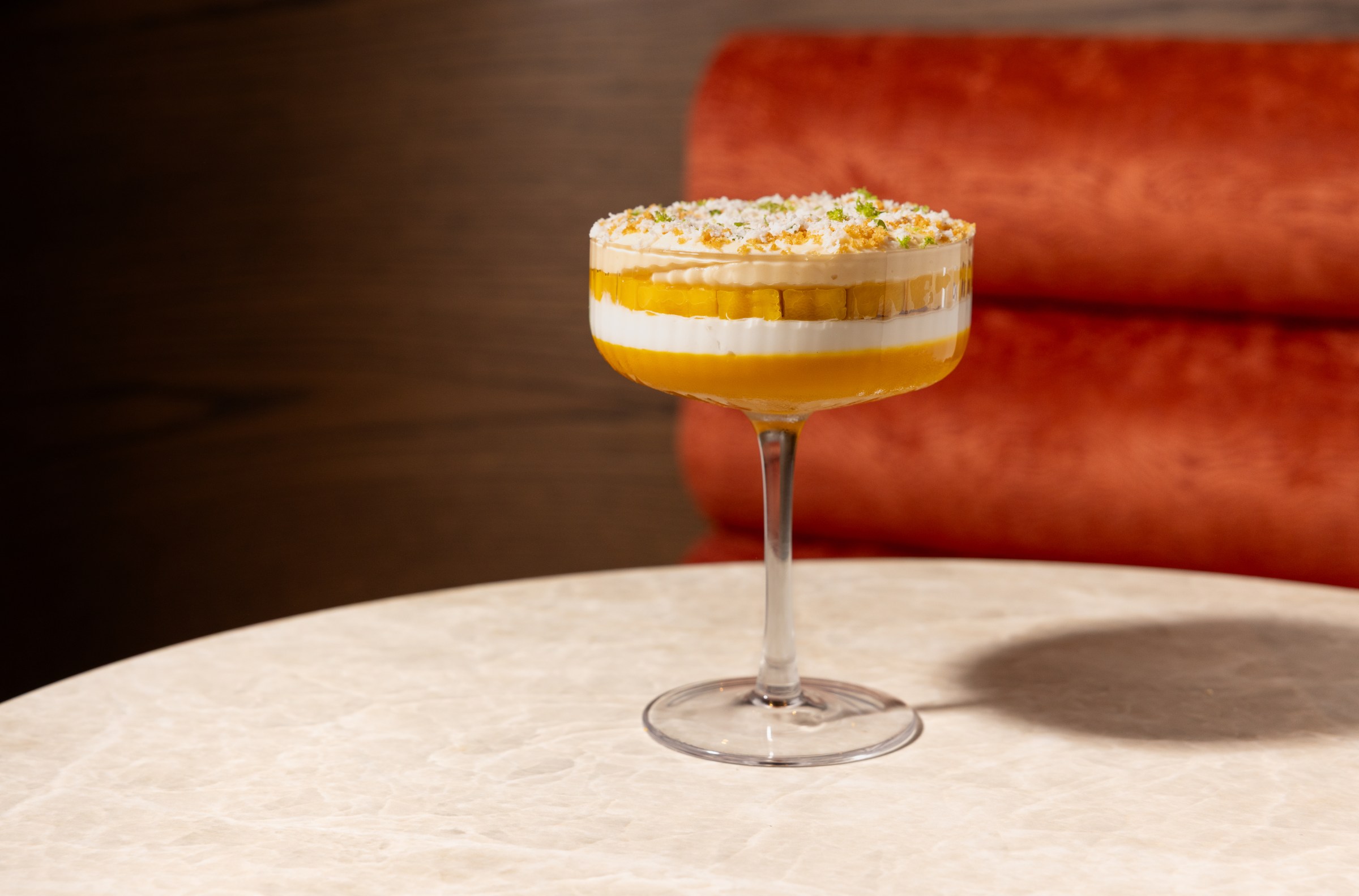 A white-and-yellow layered dessert in a glass.