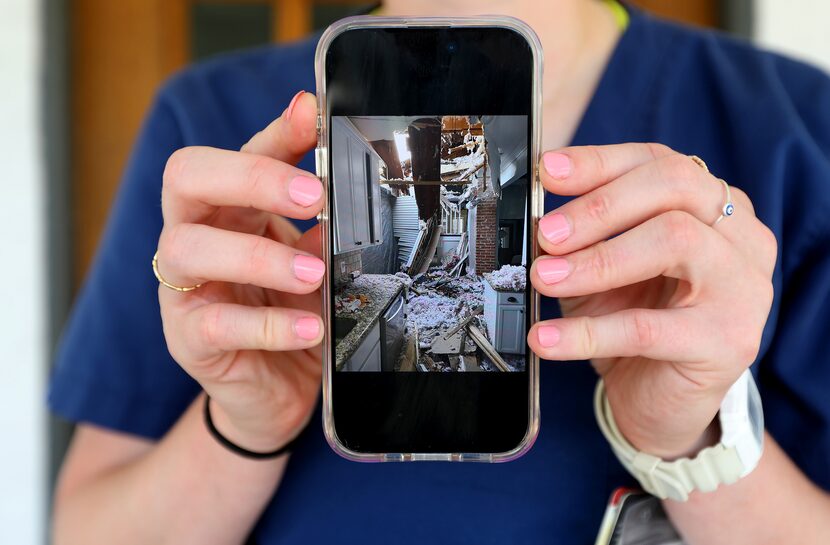 Rachel Feig holds up a photo of damage done to her home in Dallas, Texas, Friday, June 20,...