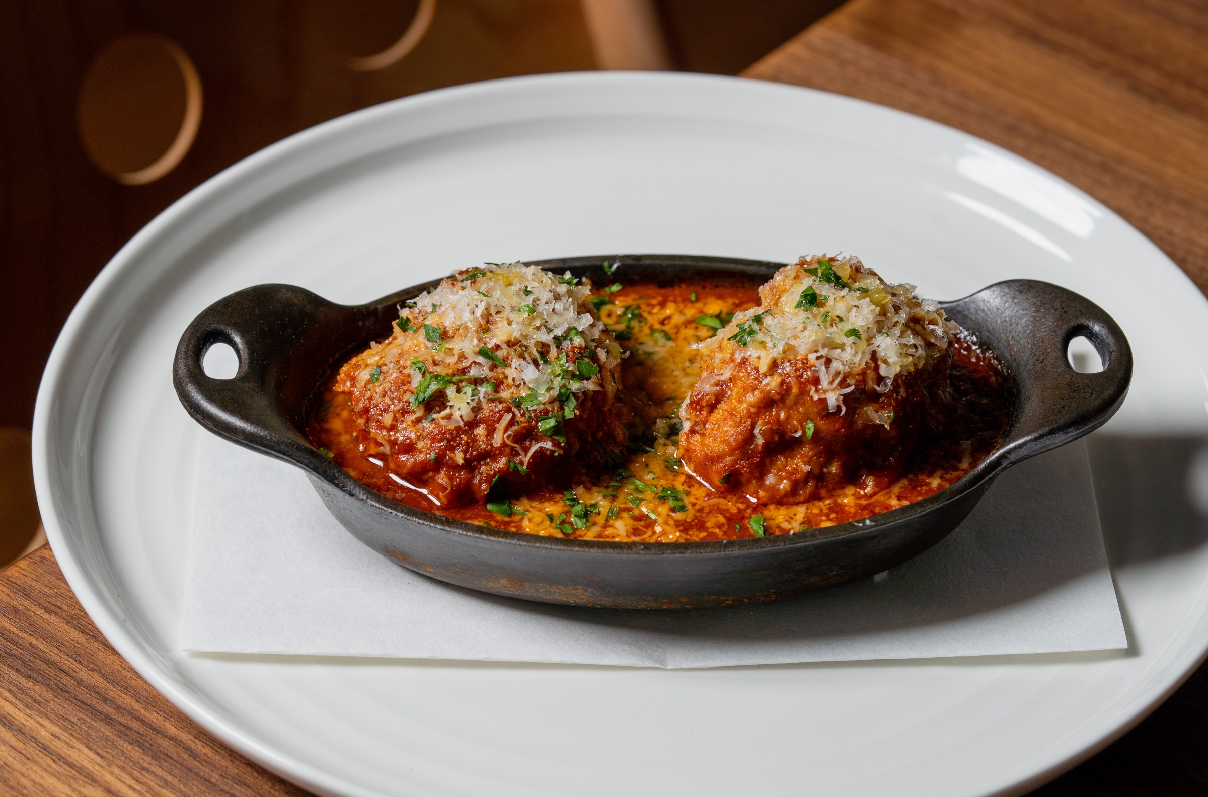 Meatballs in a shallow oblong bowl with tomato sauce