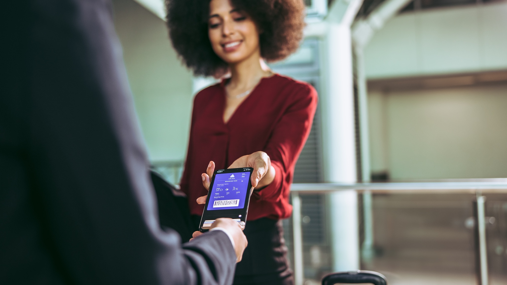 Woman using her smartphone to board an airplane with a digital pass