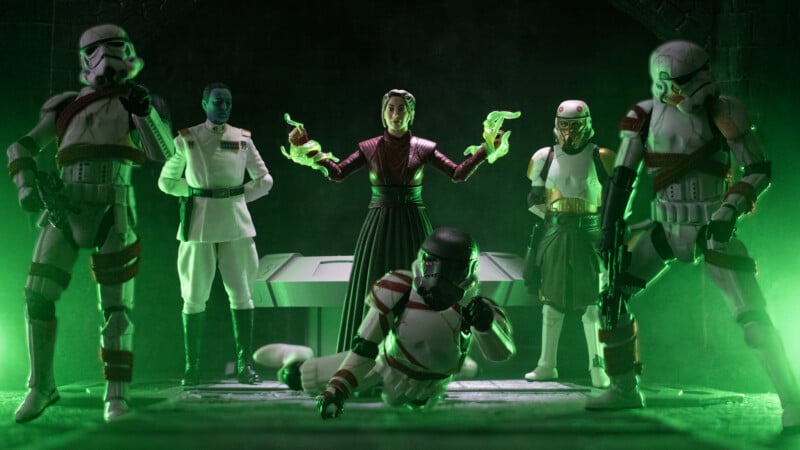 Six Star Wars action figures are posed dramatically in green foggy light. A central figure gestures with glowing green hands; others, including stormtroopers and two officers, stand or kneel around a futuristic table.