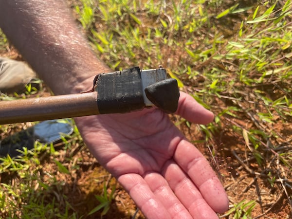 Dr. Ed Albin holds a meteorite from the Georgia fireball against a rare Earth magnet.