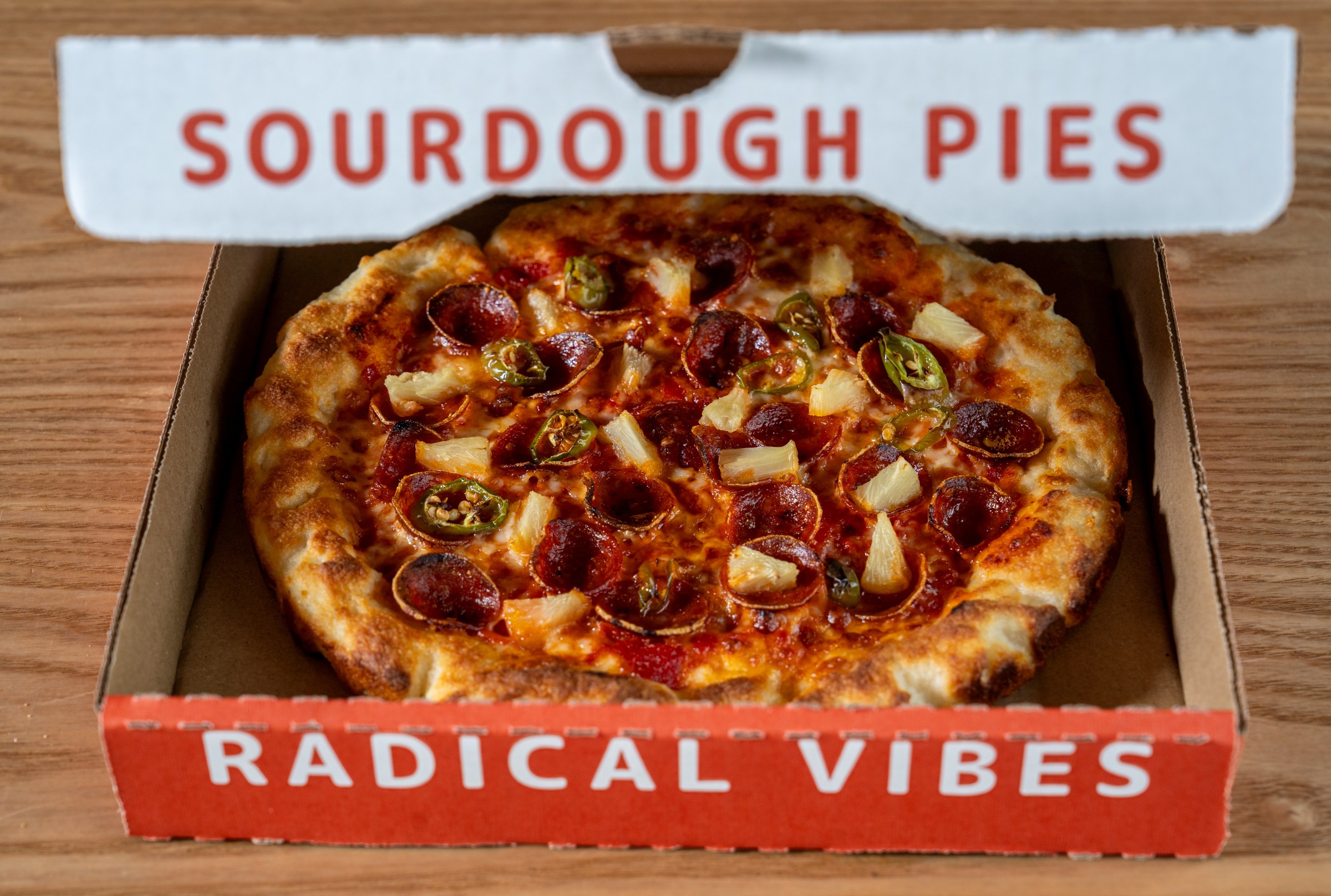 Puffy crusted pizza in a pizza box from Odie’s Pizza