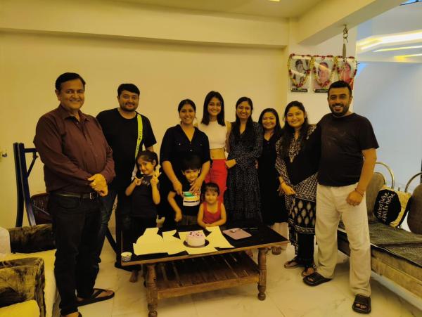 Gracy, in the centre wearing a white shirt and red skirt, her father at the extreme left