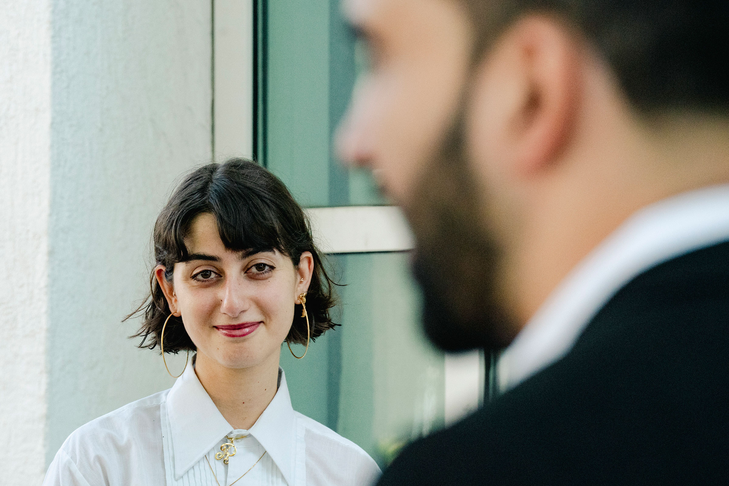 Rama Duwaji, wife of democratic socialist mayoral candidate Zohran Mamdani, looks at him as he speaks to reporters before casting his ballot in the Astoria neighborhood of Queens, June 19, 2025. (Shuran Huang/The New York Times)