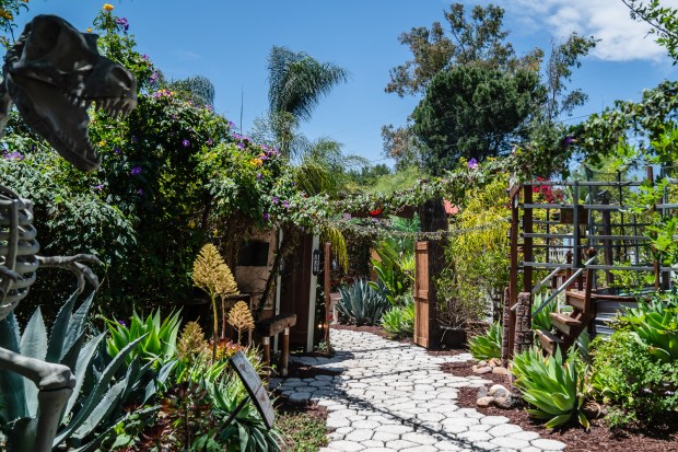 An arched gateway in the Marshalls' backyard is surrounded by...