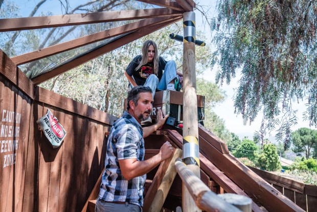 Jared Marshall helps his daughter Madison Marshall by holding the roller coaster while she gets in, in Lakeside on May 30, 2025. (Ariana Drehsler / For The San Diego Union-Tribune)