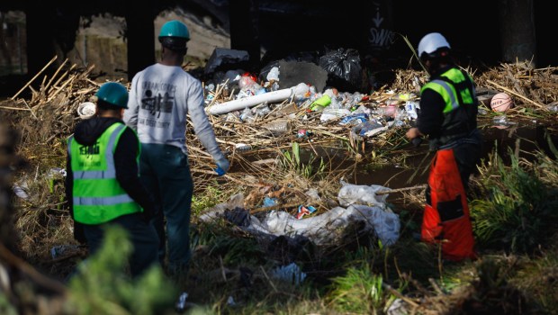 Garbage and other debris from Monday's flooding are seen piled up in Chollas Creek in Southcrest on Friday, Jan. 26, 2024. City workers have started clearing out the creek at South 38th Street and will work upstream. (Kristian Carreon / For The San Diego Union-Tribune)