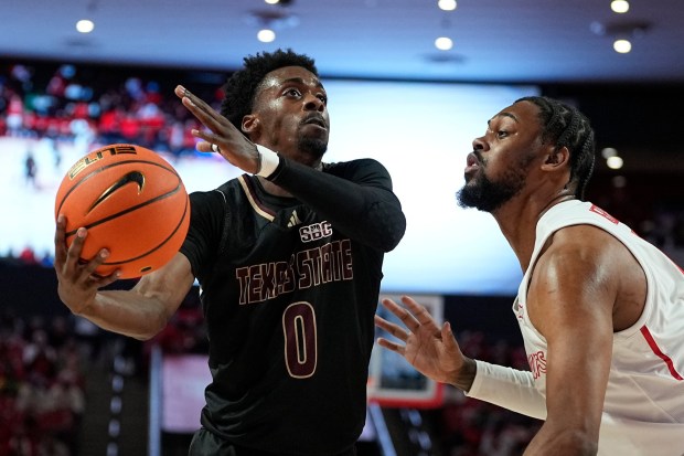 Texas State guard Dylan Dawson (0) is defended by Houston forward J'Wan Roberts (13) during the first half of an NCAA college basketball game, Thursday, Dec. 21, 2023, in Houston. (AP Photo/Kevin M. Cox)