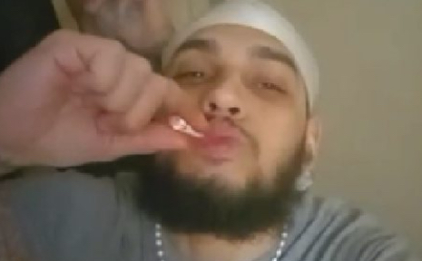 Raymond Minaya seen smoking on a video call with other inmates. (DOJ)