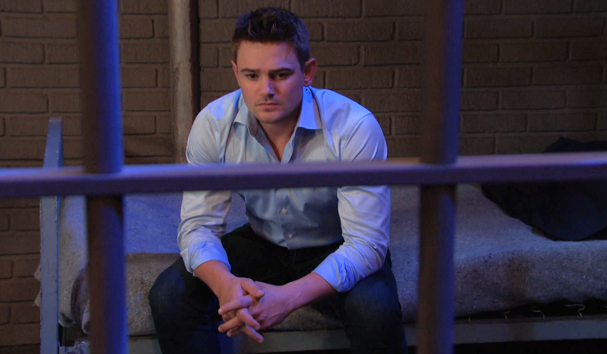 Days Johnny looks miserable as he sits on a bed in a jail cell, hands together, staring at nothing