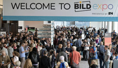 A large crowd gathers under a "Welcome to BILD expo" banner at a convention center, with directional signs for various stages and exhibitors visible.