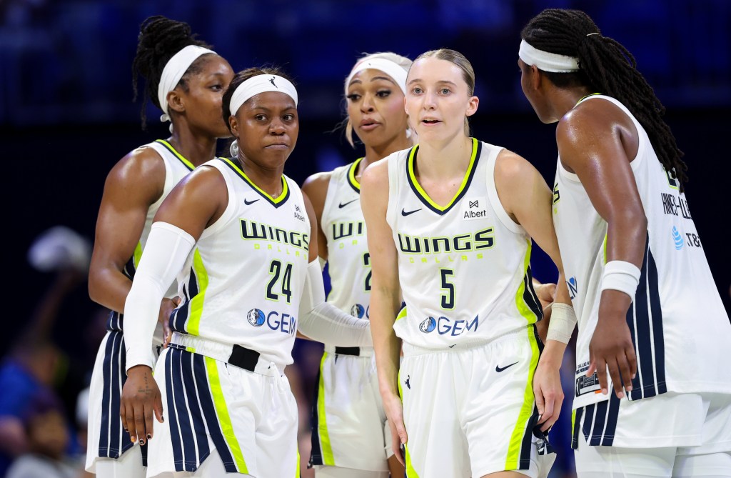 Dallas Wings players gather around guards Arike Ogunbowale and Paige Bueckers