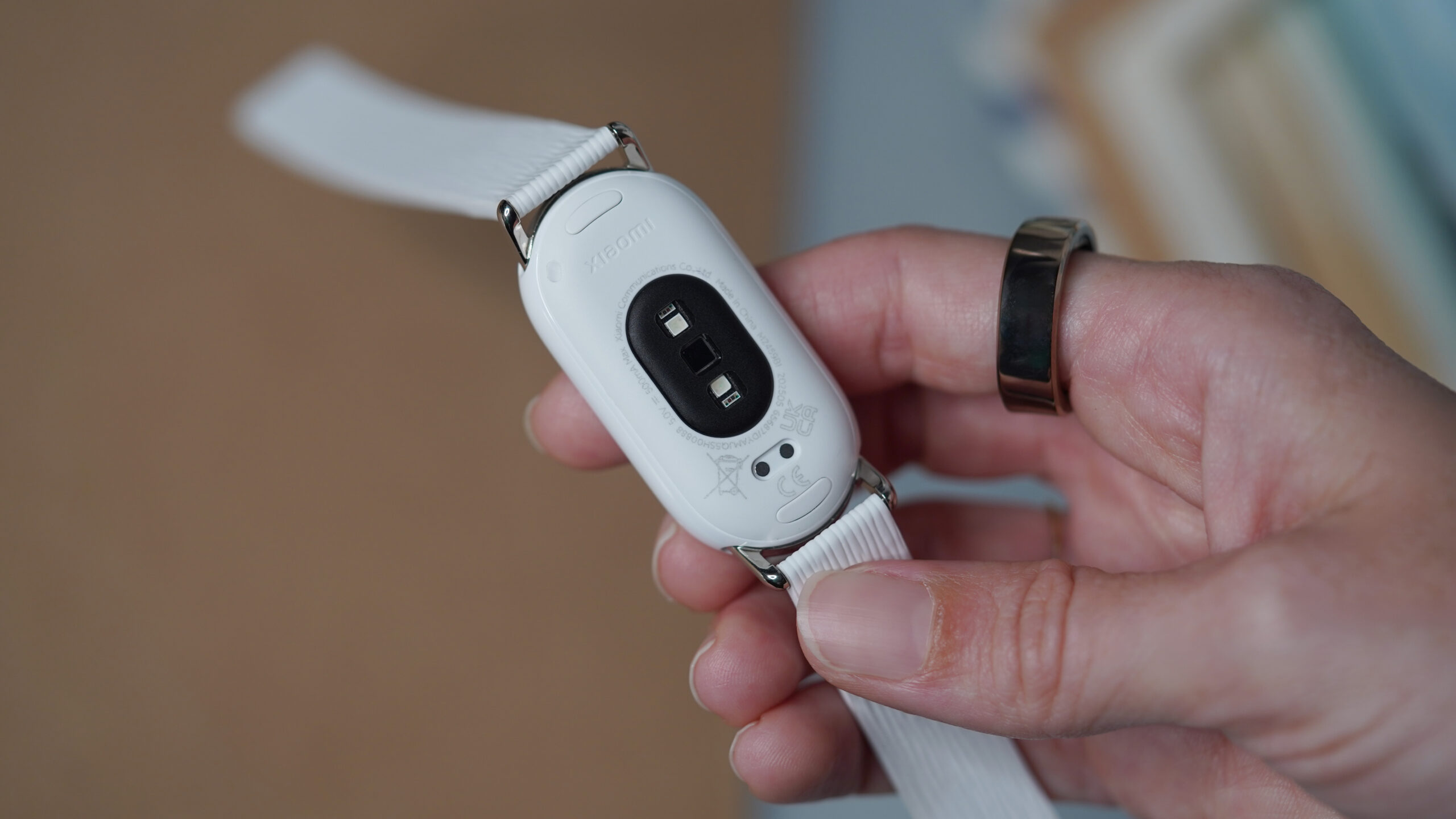 A user holds a Xiaomi Smart Band 10 band face down.
