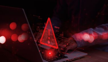Laptop with warning symbol in red denoting a cyber attack or compromised device.