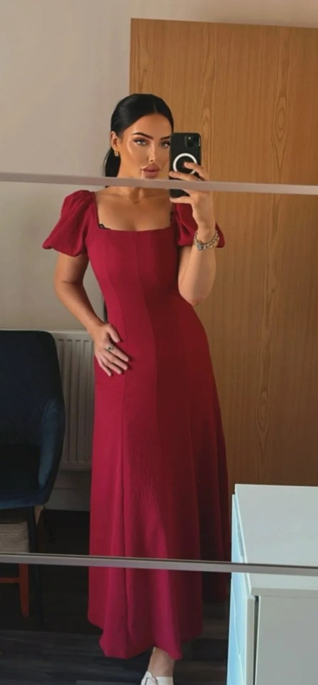 Woman in a red dress taking a selfie.