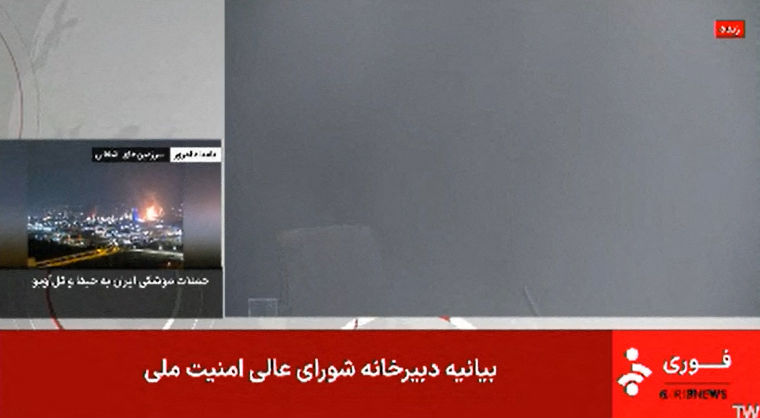 Screenshot of Iranian news broadcast showing smoke-filled newsroom after Israeli attack.