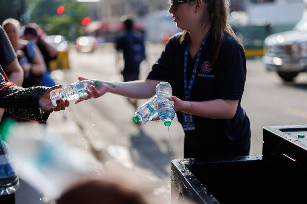 Wrigley Field employees hand out water to fans in line before Stray Kids perform at Wrigley Field on June 26, 2025.(Armando L. Sanchez/Chicago Tribune)