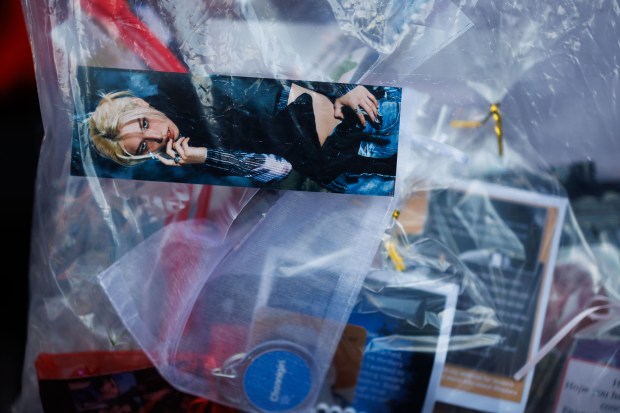 A photo of band member Felix, sits in Roxanne Kerber, 13, freebies bag - small photos, candy, or stickers given to other fans for free - before Stray Kids perform at Wrigley Field on June 26, 2025, in Chicago. (Armando L. Sanchez/Chicago Tribune)