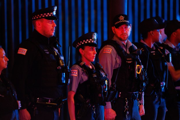Members of the Chicago Police Department watch as a procession...