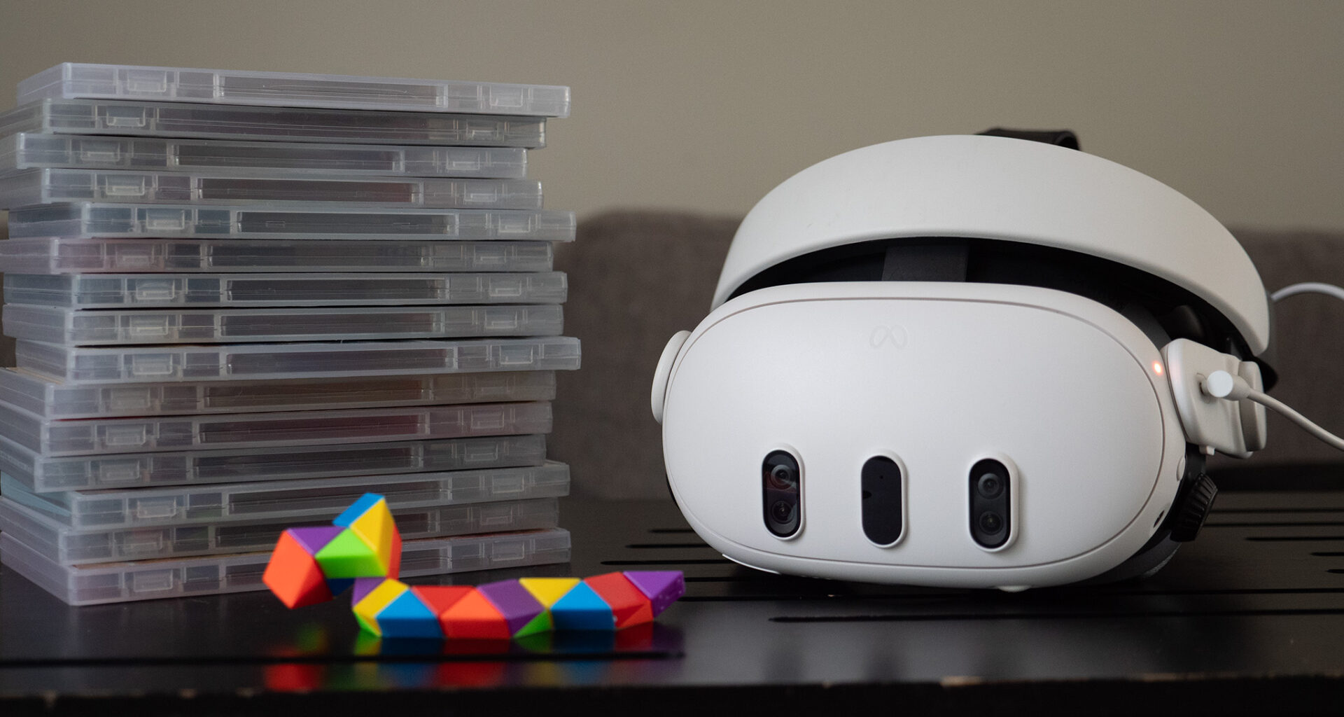 A Meta Quest 3 headset with a stack of game boxes next to it