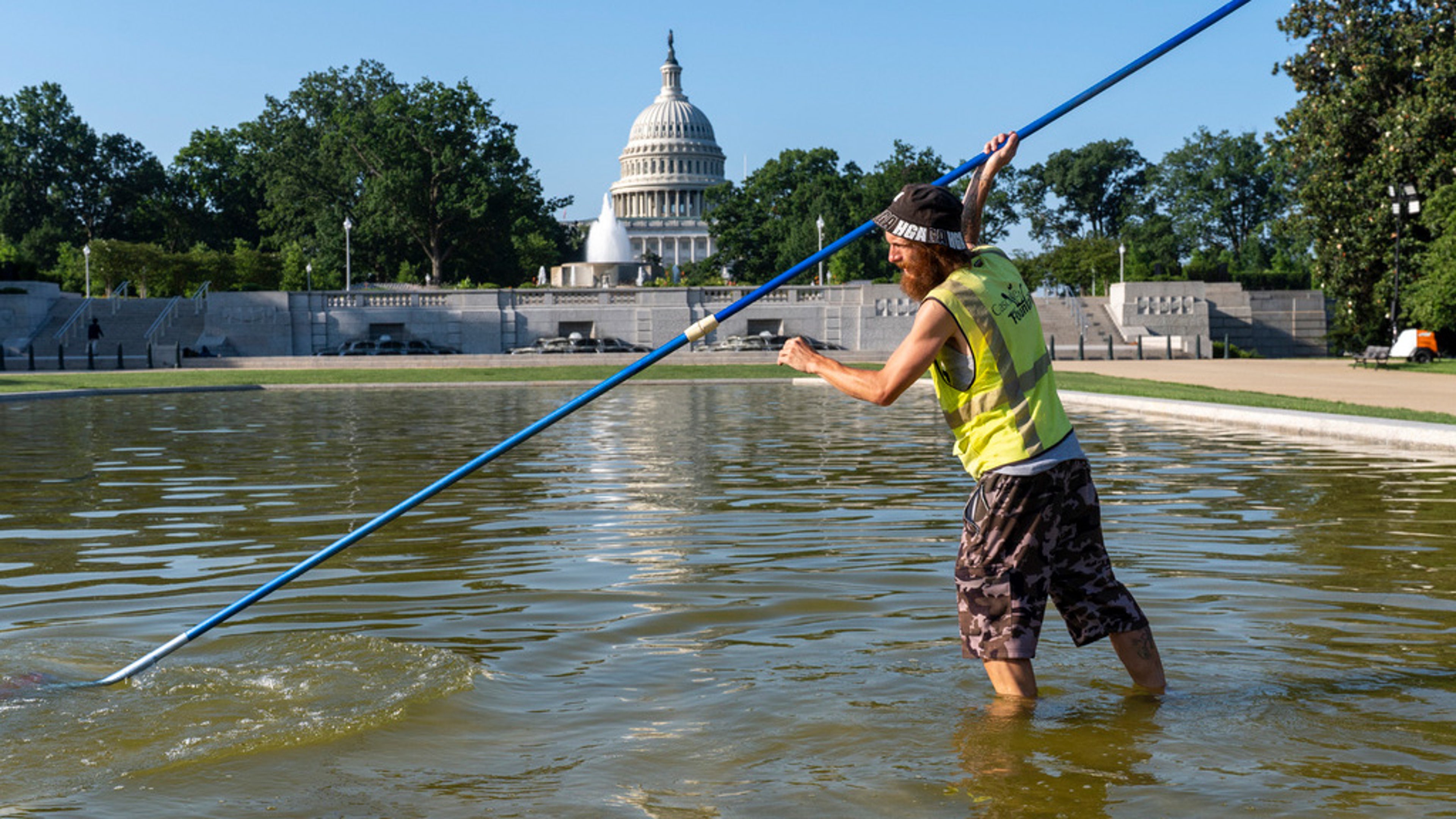 Working before the temperature hits 100 degrees today, Jeffrey Adcock cleans the reflecting pool in Lower Senate Park at the Capitol in Washington, Tuesday, June 24, 2025. (AP Photo/J. Scott Applewhite)