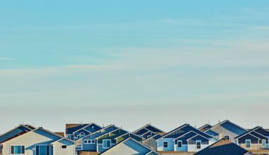 Image of the top of houses and a blue sky.