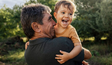 Playful grandfather spending time with his grandson in park on sunny day
