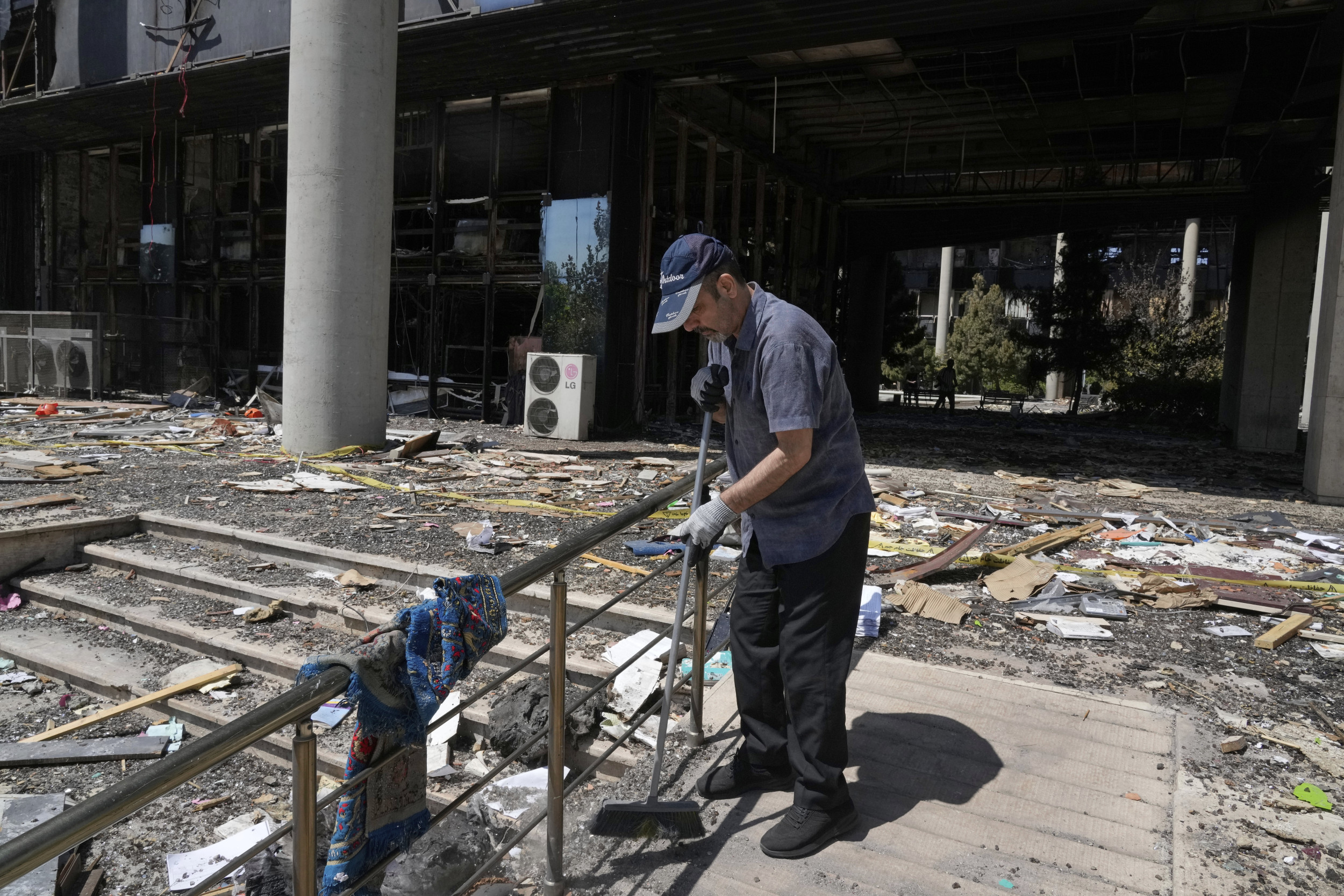 Iran worker sweeps rubble