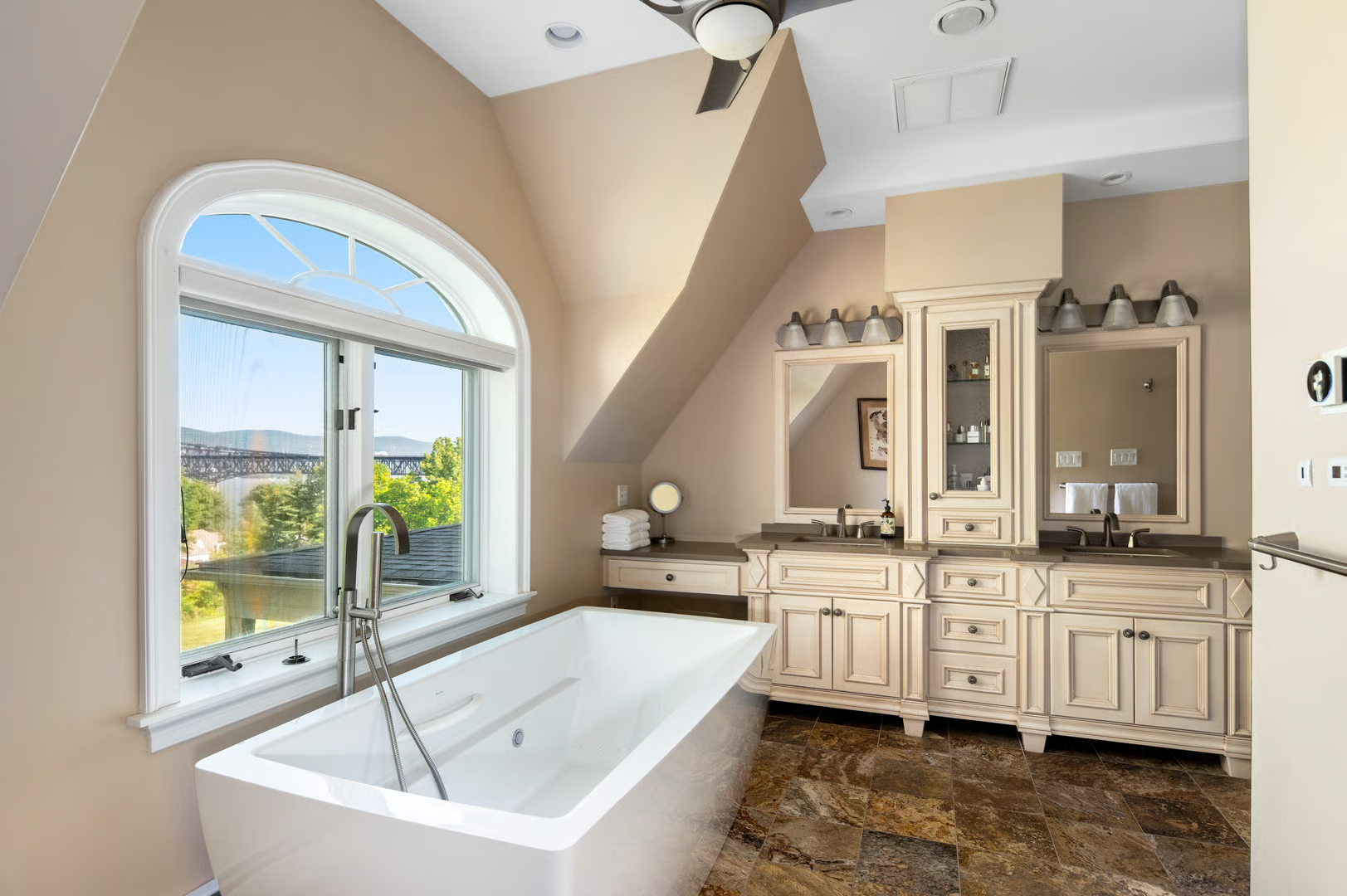 bathroom with a soaking tub and a double vanity