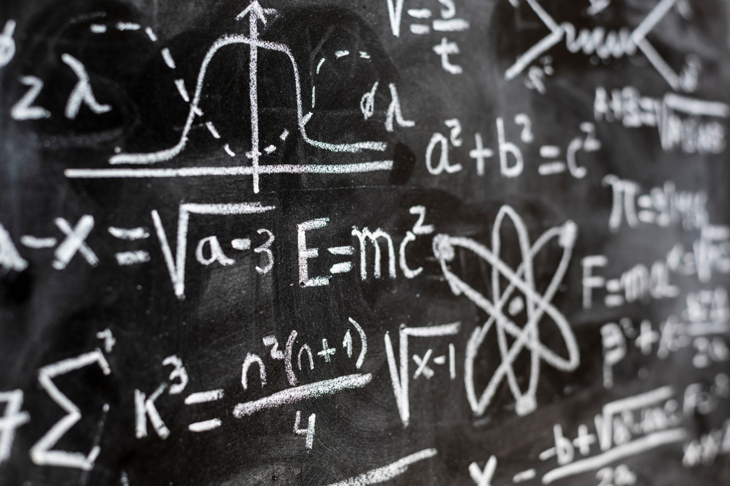 physics equations on a chalk board