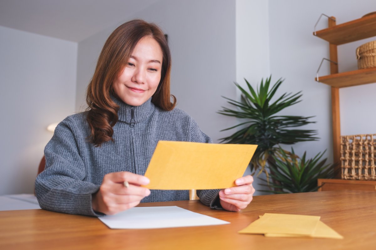 A stock image of woman reading card.